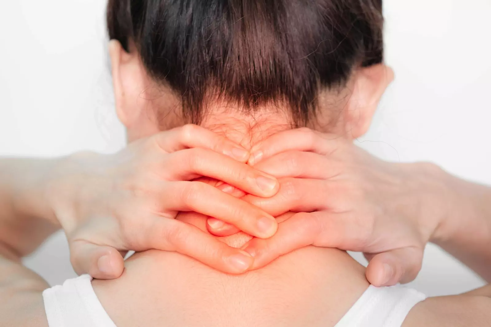 woman's hands holding the back of her neck in pain