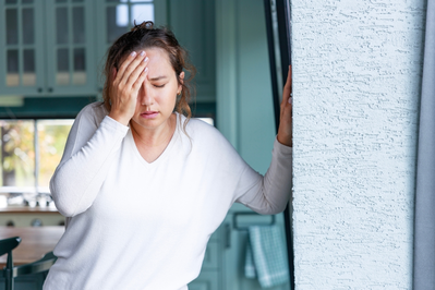 woman dizzy against wall