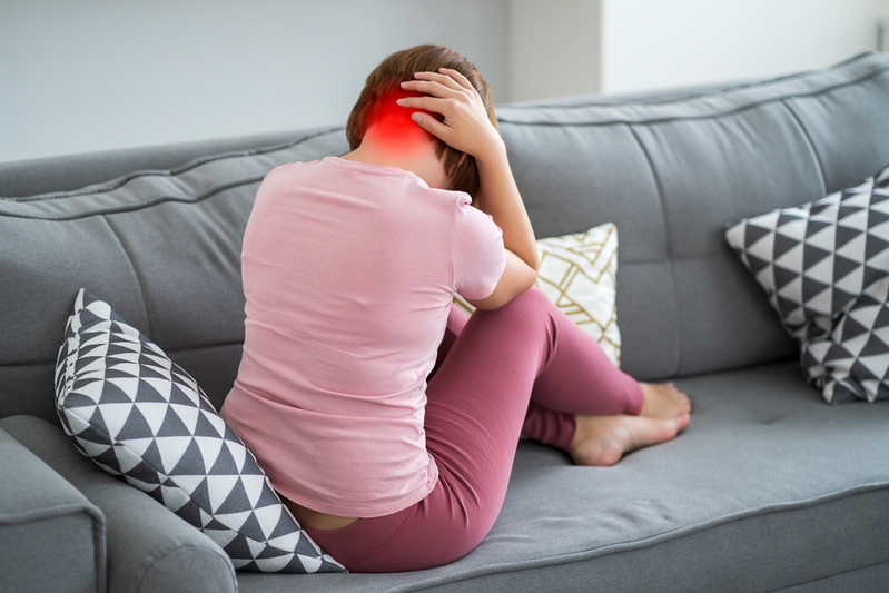 woman on couch with neck pain