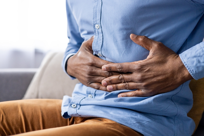 man holding stomach with gut issues